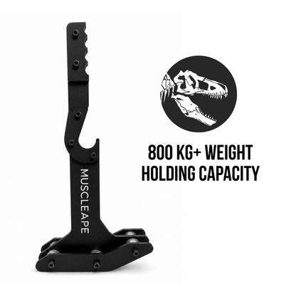 A black metal muscle arm accessory branded MUSCLEAPE, shown on a white background with a black circular graphic containing a white dinosaur skull and the text '800 KG+ WEIGHT HOLDING CAPACITY'.